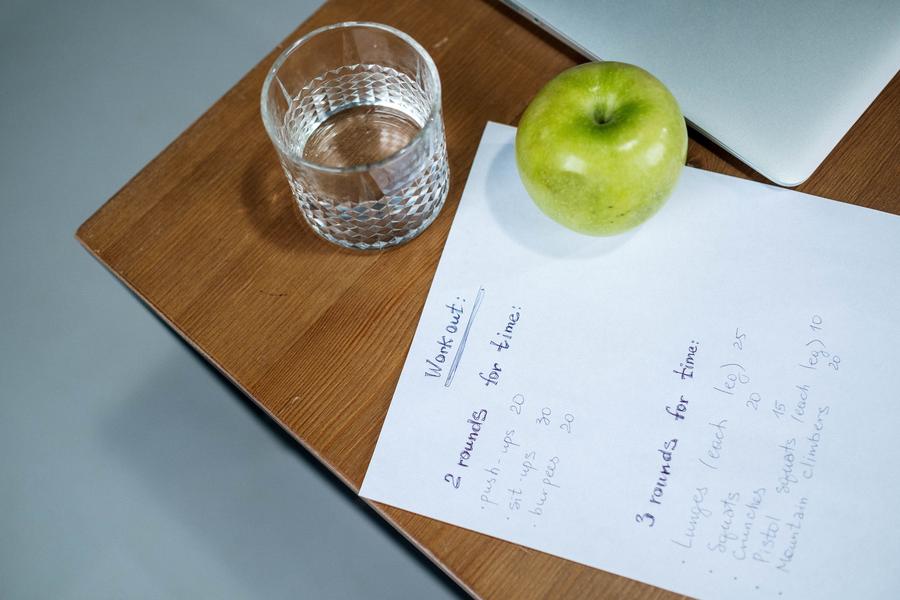 Handwritten workout plan with an apple and water
